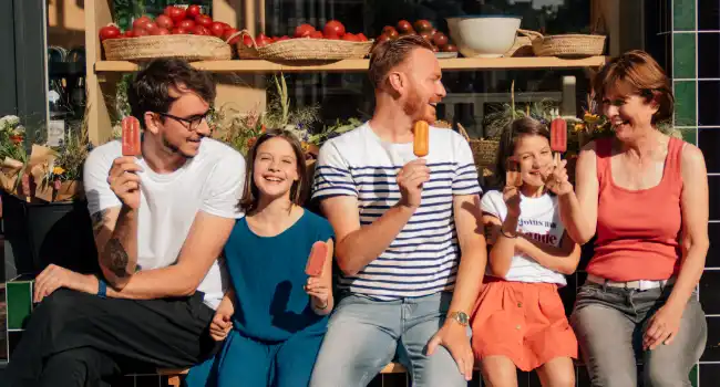 Glaces bio Hopopop : une famille savoure des bâtonnets glacés aux fruits, glaces saines et rafraîchissantes.